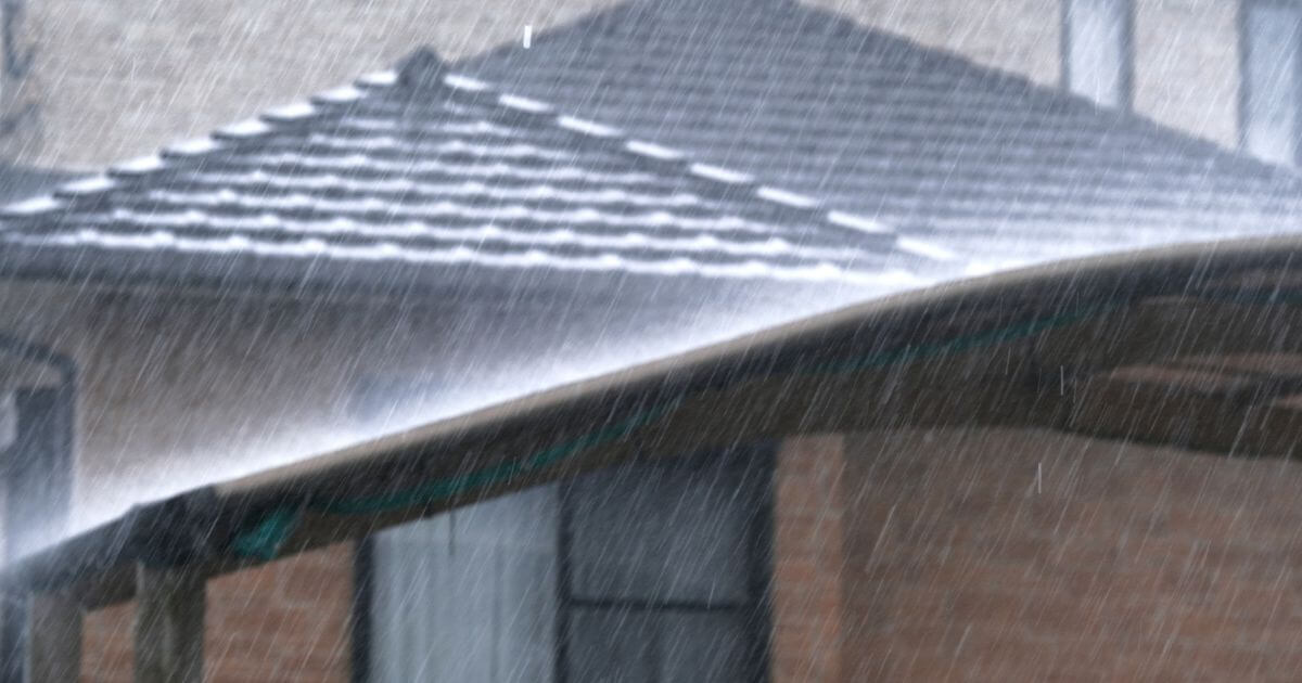 土砂降りの雨が家の屋根に直撃している様子